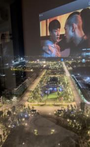 a view of a city at night with a large screen at Cherry Home in Ðan Phô