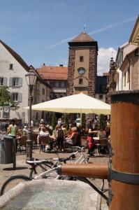 a group of people sitting at tables under an umbrella at Loft Style Studio - historic old town in Villingen-Schwenningen