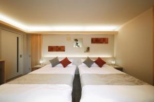 two beds in a hotel room next to each other at はく HIROSHIMA Station HOTEL in Hiroshima
