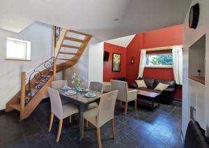 a living room with a table and chairs and a staircase at Gîtes Chambres d'hôtes de charme B&B - La Cense du Pont - Campagne de Lille in Bachy