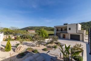 a house with a garden in front of it at Countryside family villa with pool Zmina in Donji Muć