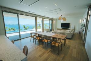 a living room with a table and chairs and a couch at SHIMASTREAM house in Shodoshima