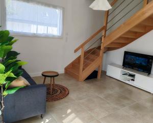 a living room with a staircase and a television at YDIWEN Maison Tregunc in Trégunc