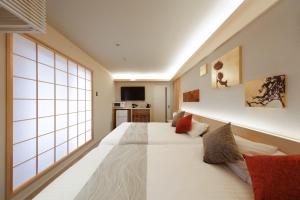 a bedroom with a large white bed in a room at はく HIROSHIMA Station HOTEL in Hiroshima