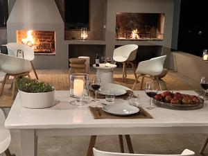 a dining room with a table with wine glasses and a fireplace at Aardvark Bioreserve in Ladismith