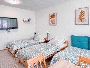 a room with three beds and a flat screen tv at ViVi Apartments in Liptovský Mikuláš