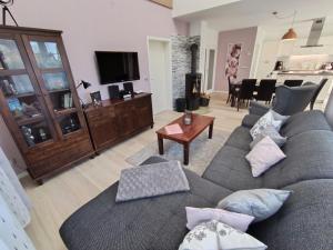 a living room with a gray couch and a table at Ferienoase Müller in Lichtenhain +53 photos
