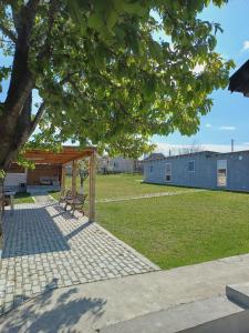 a picnic shelter in a park with a building at Arca lui Roman in Furceni
