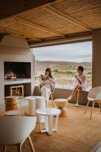 a man and woman sitting in a living room with a fireplace at Aardvark Bioreserve in Ladismith