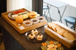 a table with a tray of food with sandwiches and bread at Silver Stone Studio Apartments in Gjirokastër