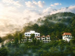 a group of buildings in front of a mountain at Wonderland Resort Chiangmai in Chiang Mai