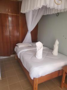a bedroom with two beds with white sheets at Torchys in Kisumu