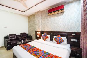 a hotel room with two beds and a chair at FabHotel The Max in Lucknow +36 photos