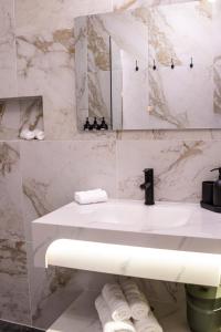 a bathroom with a sink and a mirror and towels at Maison Caliya in Saint-Didier-en-Velay