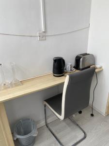 a desk with a chair and a toaster on it at Varditchy in Redbridge