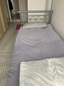 a bed in a small room with a bedskirtspectspectssenalsenalsenalsenal at Varditchy in Redbridge