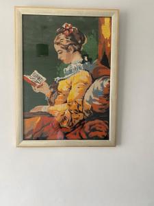 a framed painting of a woman holding a book at Varditchy in Redbridge