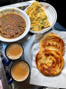 a tray of food with bread and a cup of coffee at Khushal Residence in Peshawar