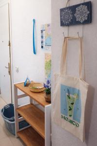a tote bag hanging on a wall next to a table at ESTUDIO Torrevieja P & A - Piscina y Playa La Mata 3 min in La Mata +21 photos