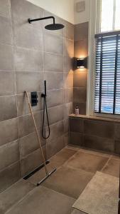 a bathroom with a shower with a shower head at Casa Peper Rosso in Rotterdam