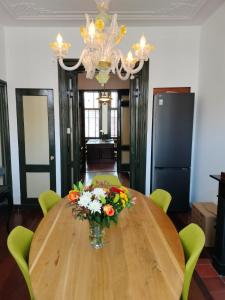a dining room table with a vase of flowers on it at Casa Peper Rosso in Rotterdam