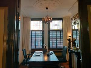 a dining room with a table with a laptop on it at Casa Peper Rosso in Rotterdam