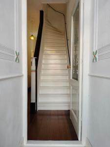 a hallway with a stairway with white stairs at Casa Peper Rosso in Rotterdam +41 photos