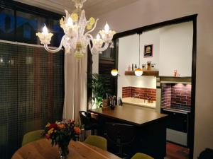 a dining room with a table and a chandelier at Casa Peper Rosso in Rotterdam