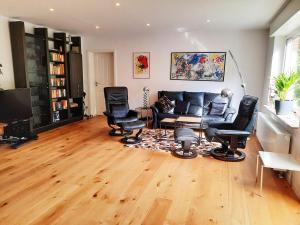 a living room with a couch and chairs and a television at Modern apartment Selm Cappenberg in Selm +2 photos