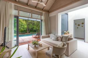 a living room with a couch and a tv at Flora Creek Chiang Mai in Hang Dong
