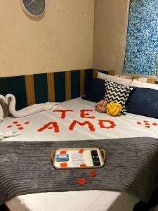 a bed with blood on it with a phone on it at Apartamento Reserva Sapiranga in Praia do Forte