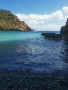 a large body of water with rocks in it at Mani GuestHouse in Kyparissos +4 photos