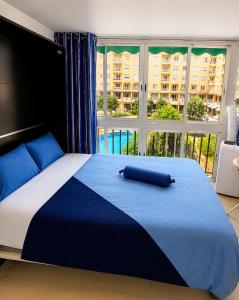 a large bed in a bedroom with a large window at ESTUDIO Torrevieja P & A - Piscina y Playa La Mata 3 min in La Mata