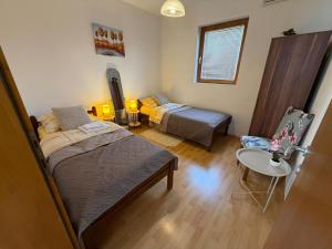 a bedroom with two beds and a table and a chair at Apartments Avram in Vršac