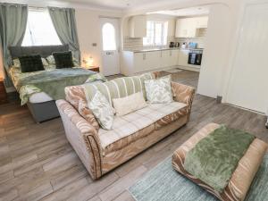 a living room with a couch and a bed at Annexe Meadows Farm in Swansea