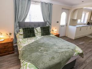 a bedroom with a bed and a kitchen at Annexe Meadows Farm in Swansea