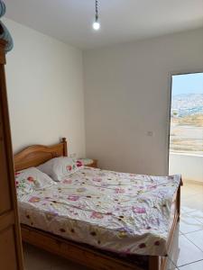 a bedroom with a bed with a floral comforter at RiF Services in Al Hoceïma