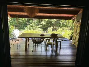 a wooden table and chairs on a deck with a table at Chambre De L étang in Saint-Paul