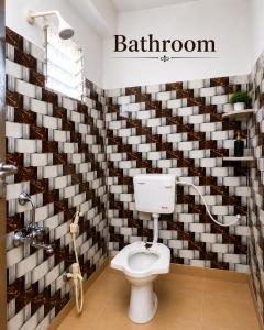 a bathroom with a toilet and a wall of cups at Laxmi Narasimha homestay in mayapur