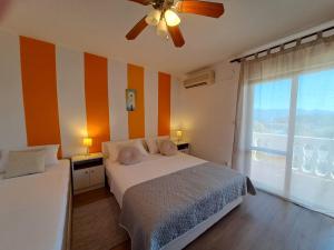 a bedroom with a bed with orange and white stripes at Holiday House Piacun in Sućuraj