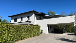 a white building with a hedge in front of it at Wohlfühlapartments Steiner in Altmünster