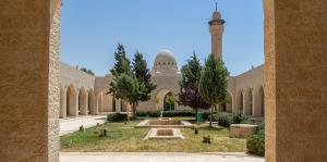 a large building with a mosque with a clock tower at golden apartment - karak - thaniyah الكرك الثنية in Kerak