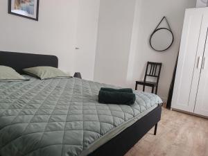 a bed with a green comforter in a bedroom at YDIWEN Maison Tregunc in Trégunc