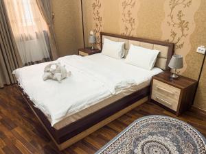 a bedroom with a bed with a teddy bear on it at Hotel Gold Begim in Fergana