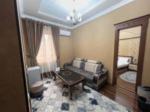 a living room with a couch and a mirror at Hotel Gold Begim in Fergana +4 photos