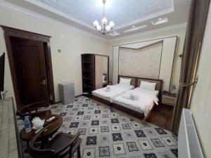 a bedroom with a bed and a table and chairs at Hotel Gold Begim in Fergana