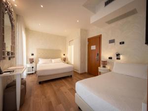 a hotel room with two beds and a bathroom at Hotel Florida Lerici in Lerici
