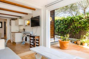 a kitchen and living room with a sliding glass door at Cel Pins in Portopetro