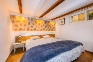 a bedroom with a bed with a blue blanket at Cel Pins in Portopetro
