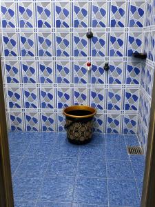 a blue and white tiled bathroom with a pot on the floor at BlueWaves in Pondicherry +38 photos